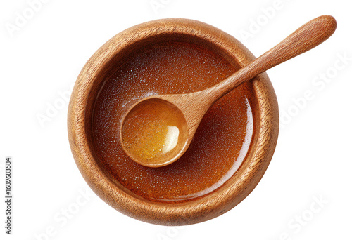 Wooden bowl filled with golden liquid, a wooden spoon inside