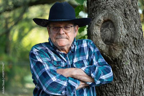 Canvas Print Portrait of a handsome elderly man in his 80s leaning against a tree outdoors sm