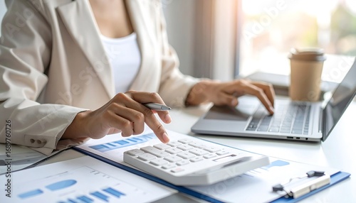 Businesswoman working on laptop and calculator