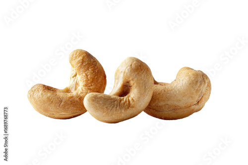 Three whole cashews, light golden brown,  close-up,  isolated on black