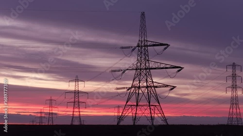 Electricity Pylons Silhouetted Against a Dramatic Pink and Purple Sunrise Sky in the Rural Yorkshire Landscape
