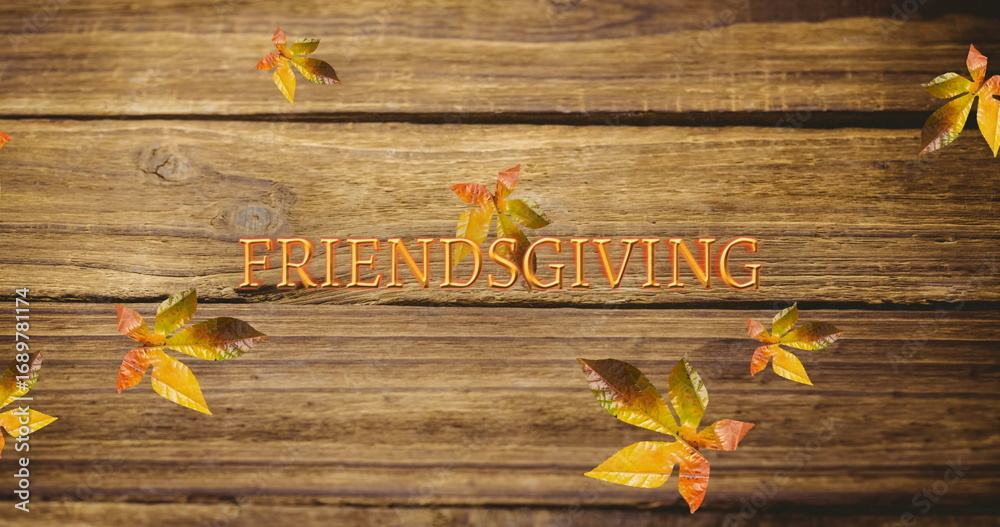 Fototapeta premium Image of friendsgiving text over autumn leaves on wooden boards