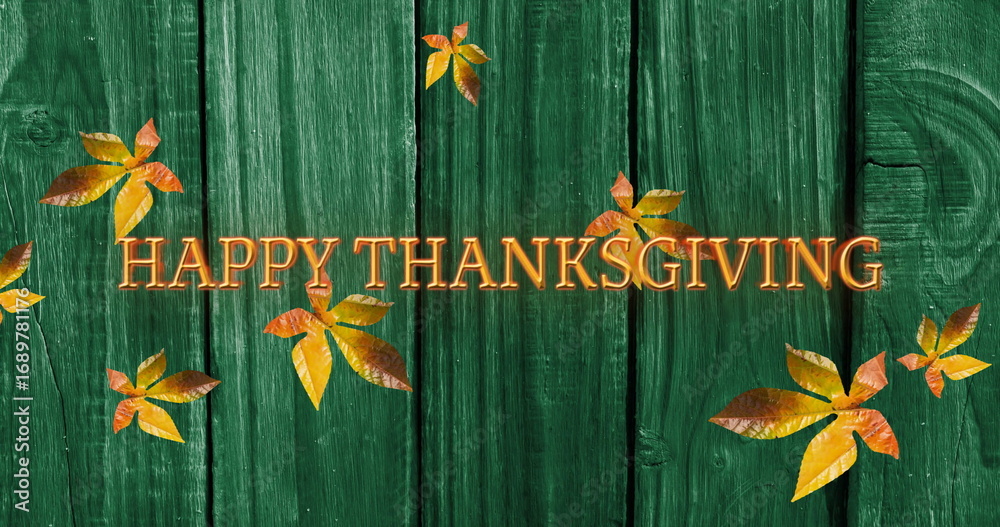Fototapeta premium Image of happy thanksgiving text over autumn leaves on green wooden boards