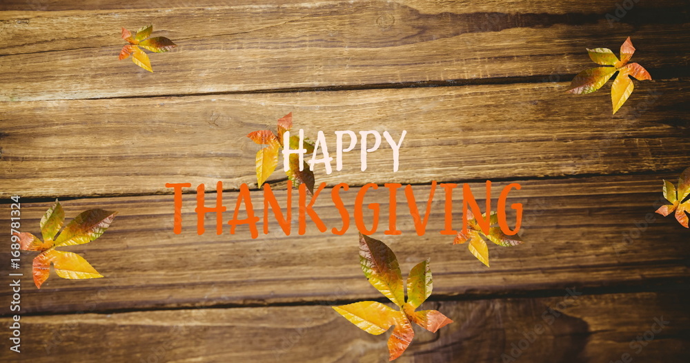 Fototapeta premium Image of happy thanksgiving text over autumn leaves on wooden boards