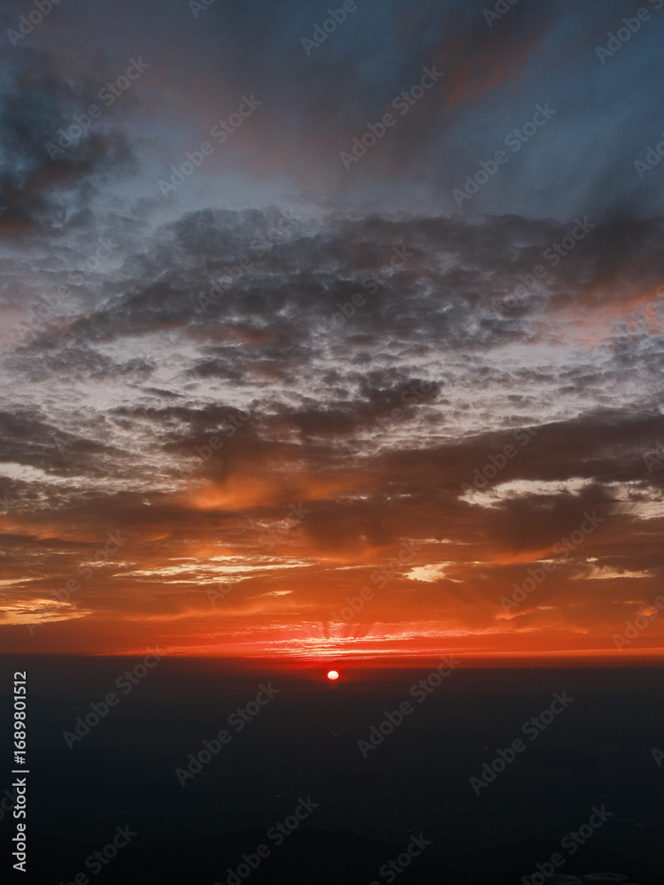 Obraz premium Dramatic Sunset Over Horizon with Vibrant Orange and Blue Sky