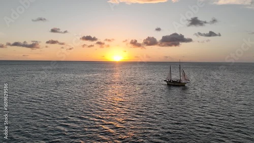 Aerial view. Old wooden sailing boat float at sunset. Cruise yacht with tourists in ocean. Romantic adventure enjoy journey in evening on sea waves.