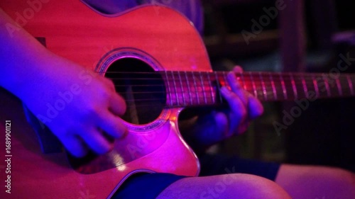 Close-up of Hands Playing Acoustic Guitar in Dim Lighting, Cozy Atmosphere with Vibrant Colors, Showcasing Musical Passion and Skillful Technique