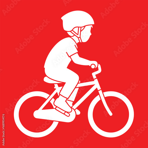 Child riding bicycle on red surface wearing helmet for safety and recreation, enjoying outdoor activity and physical exercise on bright day.