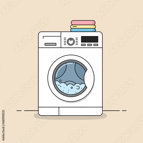 A front-loading washing machine with bubbles inside and folded towels on top.