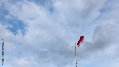 Indonesia flag waving on pole against blue sky