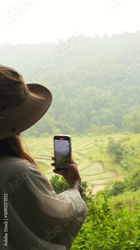 Young Woman Filming Scenic Rice Terraces with Smartphone in Northern Thailand