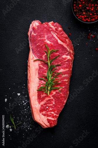Tableau sur toile Delicious raw picanha beef steak from marbled beef with a fat cushion from the rump cut with rosemary and pepper, black background