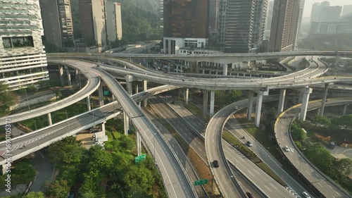 Aerial view of a complex elevated highway interchange in Malaysia, featuring multiple overlapping expressways, ramps, and lanes in an urban city setting.