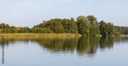 A body of water with trees in the background