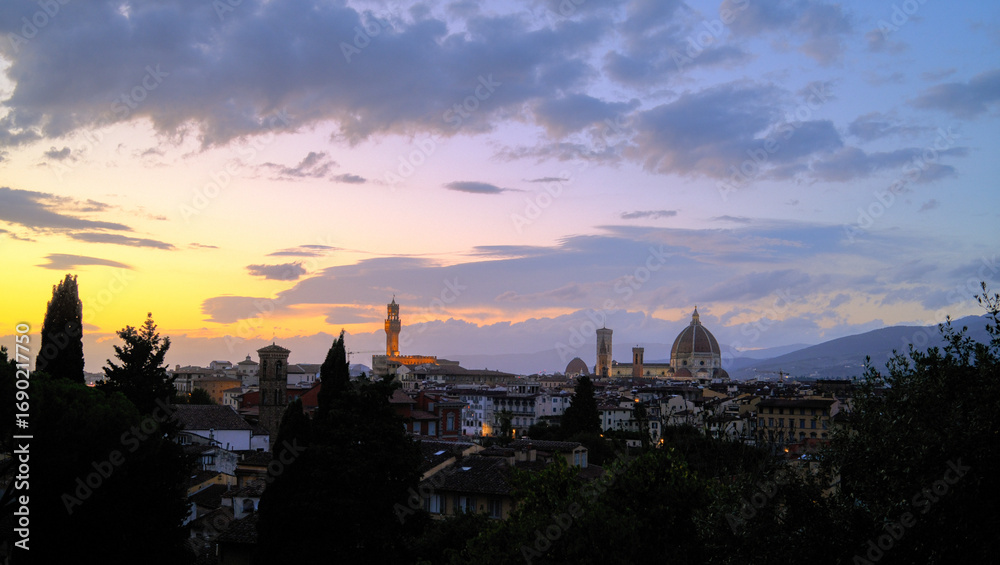 Naklejka premium Florence, Italy at night with illuminated cathedral, Arno River reflections, and historic city skyline.