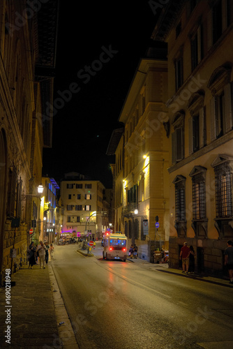 Florence, Italy at night with illuminated cathedral, Arno River reflections, and historic city skyline.