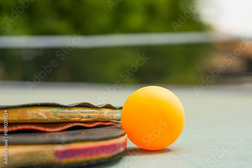 Ping pong paddles and ball on retro  blue wooden background. Rackets ruined by time