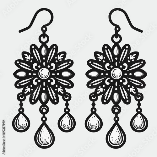 Vintage ornate earrings with teardrop pendants on a light background