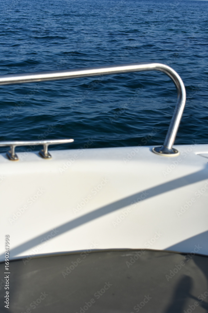 Obraz premium Close-up of a boat on the sea. Driving motorboat on holiday. Boat rental. Rhodes, Greece. Motorboat parts. Summer vacation at the sea. Tourist boat trip.