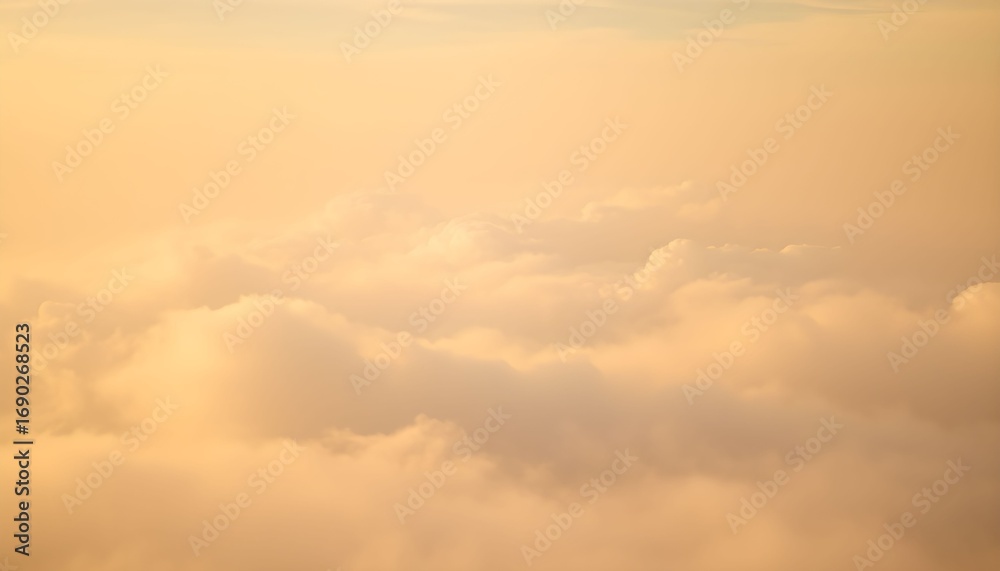 Obraz premium Golden sunset light illuminates a vast expanse of fluffy clouds viewed from above.