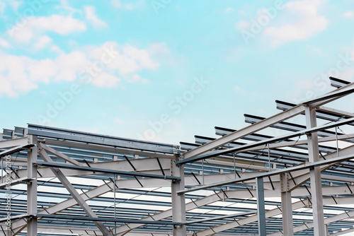 Bild auf Leinwand Modern steel structure assembly under a blue sky at a construction site in the e
