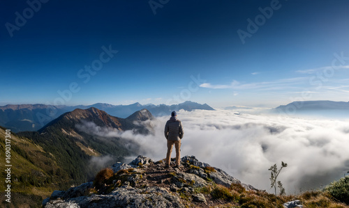 Mac standing on a mountain peak, high above the clouds. Symbolic of achieving objectives and battling adversity.