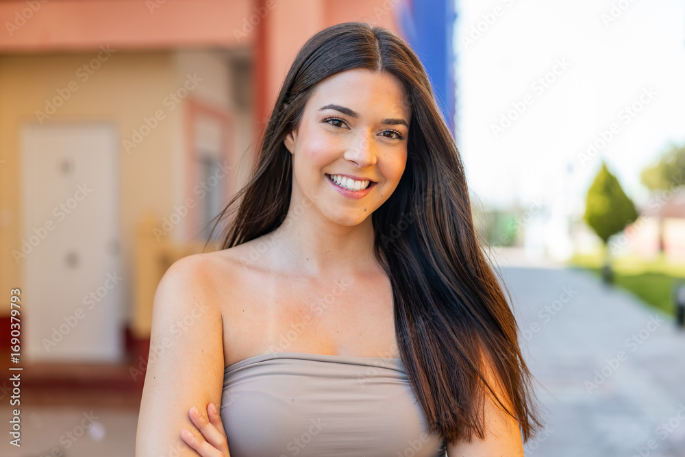 Fototapeta premium Young pretty Brazilian woman at outdoors keeping the arms crossed in frontal position