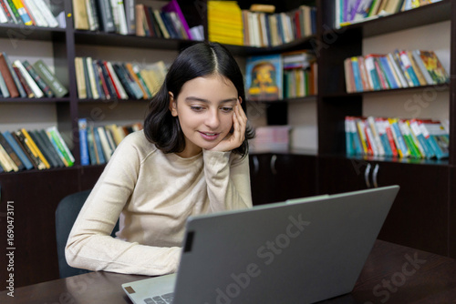 Teenage school girl working on a computer in the library