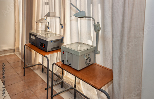 Tablou pe pânză vintage overhead projectors indoors on a table in a classroom next to the window