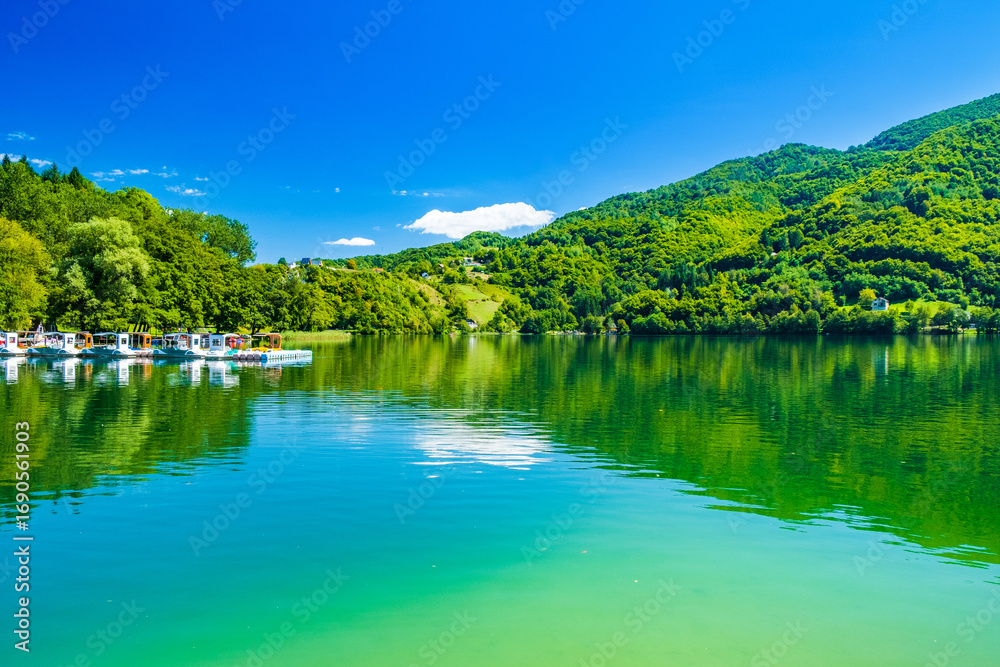 Fototapeta premium Amazing green Lake Plivsko jezero, Jajce, Bosnia and Herzegovina, wood reflection on water surface