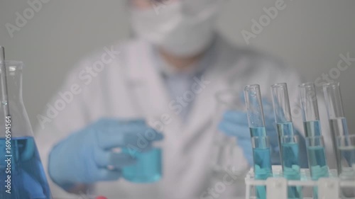 Scientist examine analyze blue fluid science test tube beaker chemistry laboratory research medicine concept