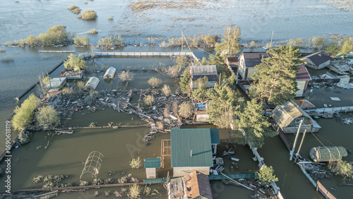 Aerial drone footage showing severe flooding with submerged houses and roads. Wide overhead view of a disaster zone after heavy rainfall, showcasing water damage, extreme weather, and climate-related 