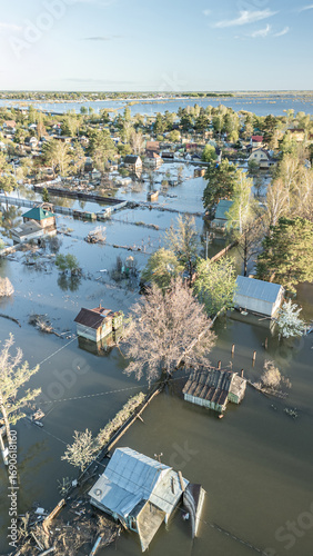 Aerial drone footage showing severe flooding with submerged houses and roads. Wide overhead view of a disaster zone after heavy rainfall, showcasing water damage, extreme weather, and climate-related 