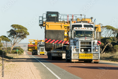 Convoy of trucks transporting oversized mining equipment on an outback highway