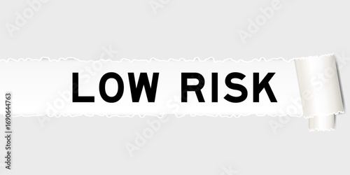 Ripped gray paper background that have word low risk under torn part