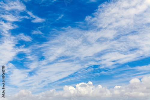 A vibrant blue sky filled with wispy cirrus clouds and fluffy cumulus formations