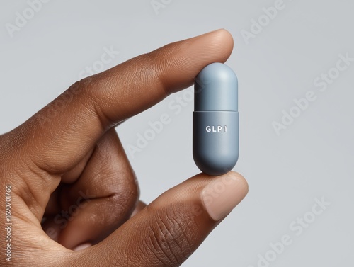 Expertly holding a blue GLP-1 capsule, representing modern health and wellness solutions.