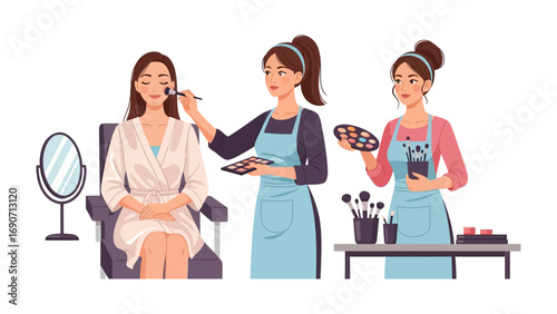 Professional makeup artist applying foundation to a young woman sitting in a chair while another artist holds a palette and brushes