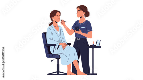 Professional makeup artist applying cosmetic makeup to a young woman sitting in a chair wearing a robe for beauty treatment