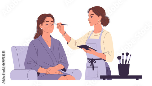 Professional makeup artist applying eyeshadow to a woman sitting in a chair wearing a robe for a beauty session