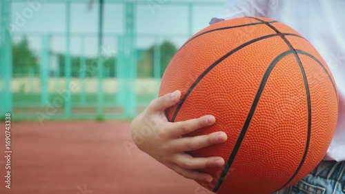 A girl with basketball on court on summer season