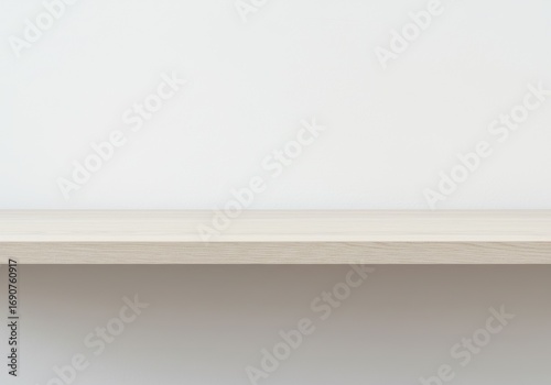 Empty light wood shelf against a neutral wall.