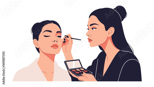 Professional makeup artist applying eyeshadow to a client with short dark hair using a palette and brush in a studio setting