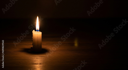 Single lit candle in dark room symbolizing hope and faith