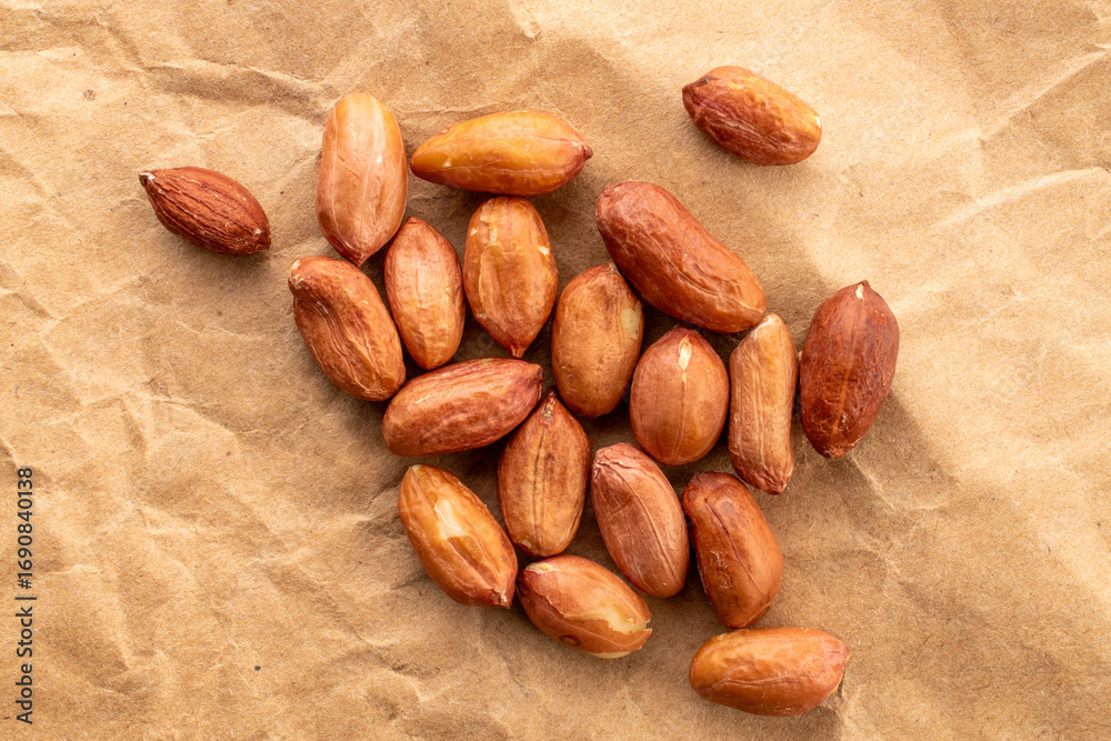 Obraz premium Peeled raw peanuts, top view, macro.