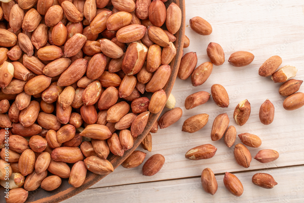 Obraz premium Peeled raw peanuts, top view, macro.