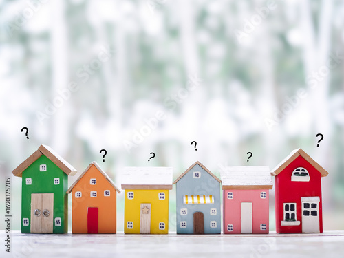 Miniature house with question mark icons.The concept of choosing suitable house for planning living in the future. Real estate