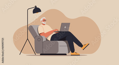 Senior man comfortably working from home on a laptop in an armchair with a lamp. Remote work, online learning, and relaxed digital lifestyle concept.