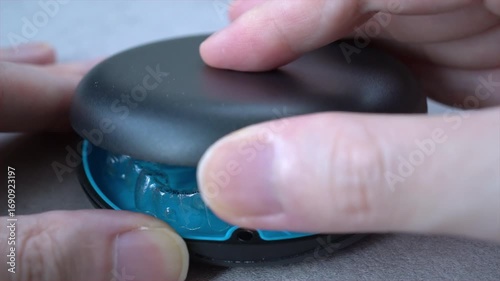 Opening blue dental aligner case that are  orthodontic mouthpiece storage in marble background. Close-up video.