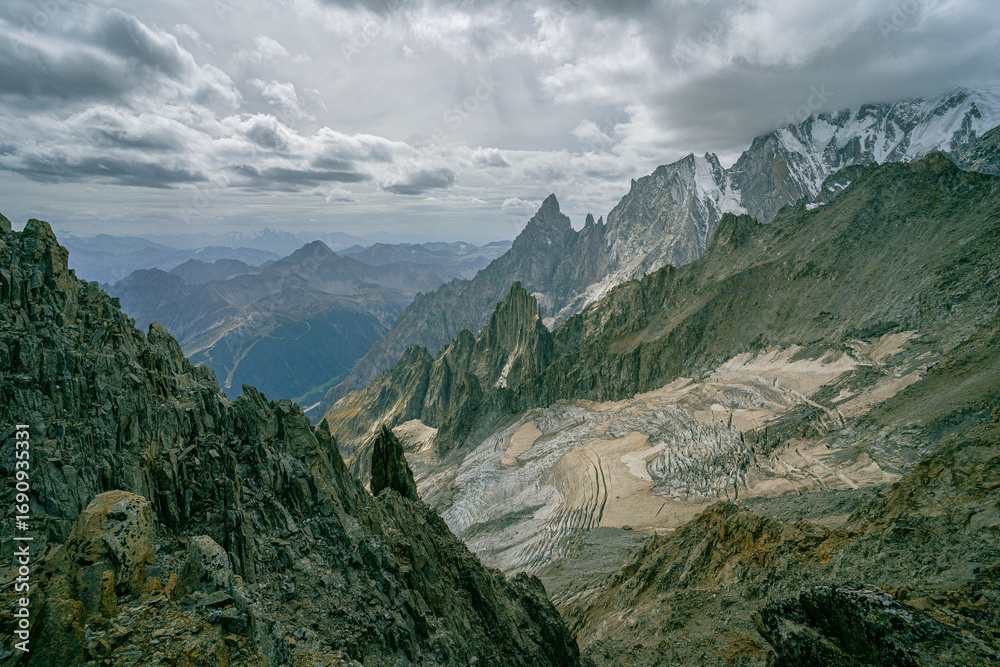Obraz premium Towering alpine spires and rugged glacier landscape under overcast sky in the Alps capturing dramatic mountain wilderness and panoramic views